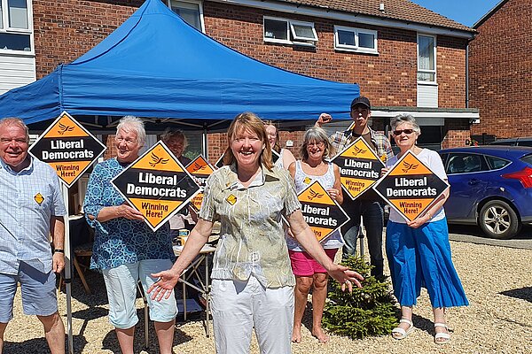 Sarah and crowd of Lib Dem campaigners on sunny day