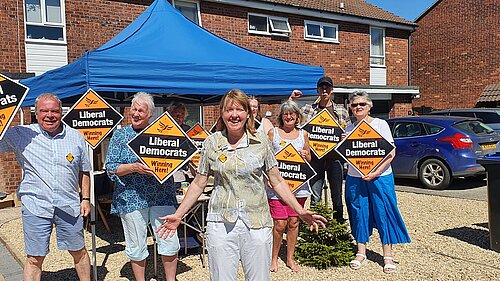 Sarah and crowd of Lib Dem campaigners on sunny day